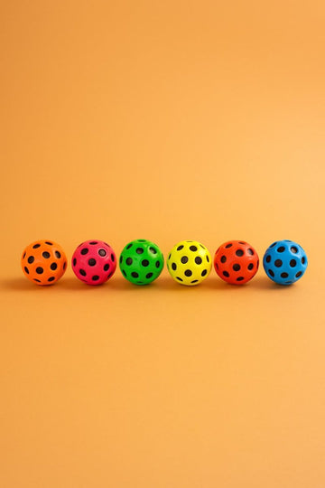 Set of colorful jumping balls, perforated surface with round dot holes in orange, pink, green, yellow