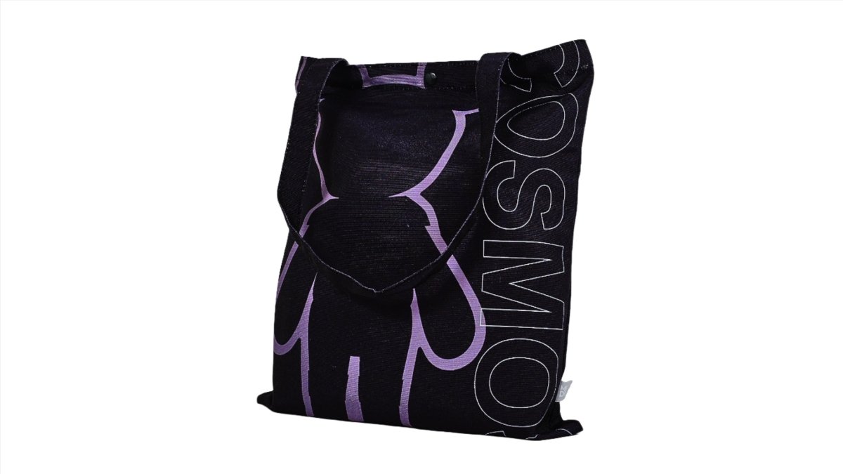 Black tote bag with purple bear print, vertical text on side, and top button