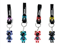 Astronaut keychains on black straps with blue, teal, red, and dark figures