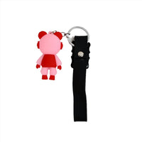 Astronaut cartoon keychain with pink-red figure, black strap, and metal key ring