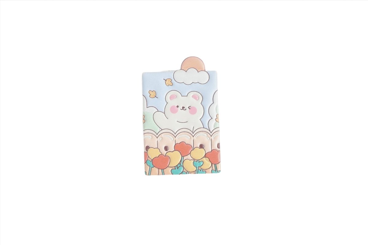 Compact mirror cover featuring a cute bear face with pastel clouds and flowers.