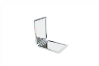 Compact mirror opened flat with clear reflective surface and hinged metal frame.