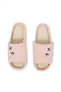 Pink fabric house slippers with beige interior and stitched bear-face motifs
