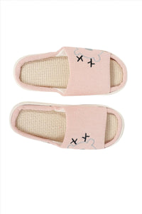 Pink fabric house slippers, pair view, beige insoles with stitched motifs