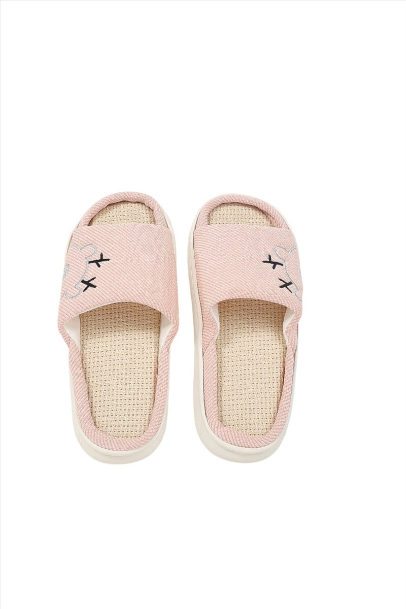 Pink fabric house slippers, front view, beige lining and stitched motifs