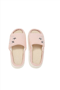 Pink fabric house slippers, front view, beige lining and stitched motifs