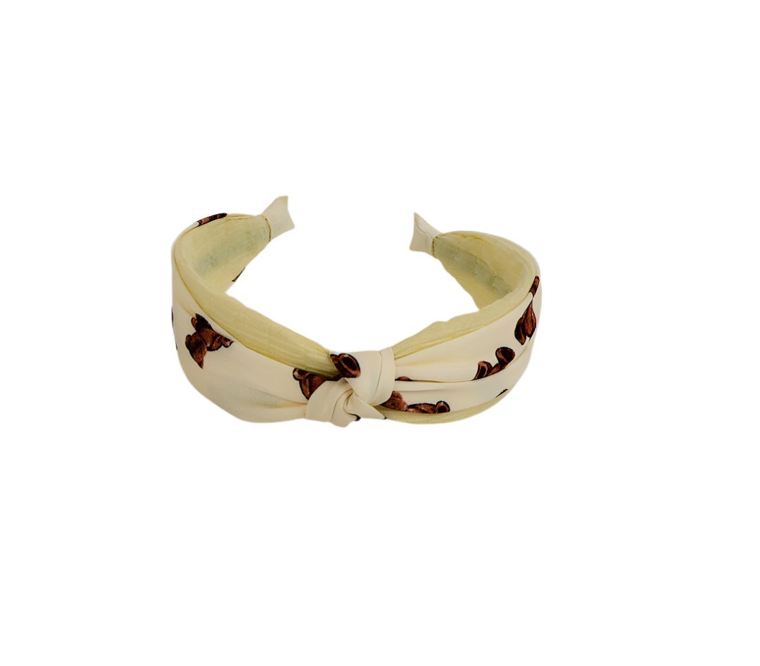 Knotted printed hairband in pale yellow with brown motif, tied knot at front