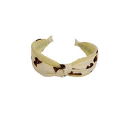 Knotted printed hairband in pale yellow with brown motif, tied knot at front