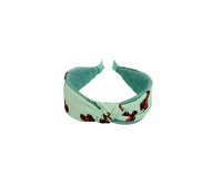 Knotted printed hairband in mint green with brown motif, knotted center