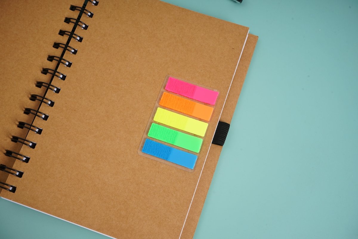 Spiral notebook with stacked color sticky tabs on kraft brown cover