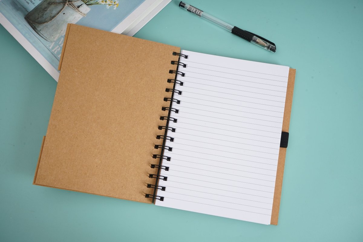 Open spiral notebook with lined pages and black pen clipped at the side