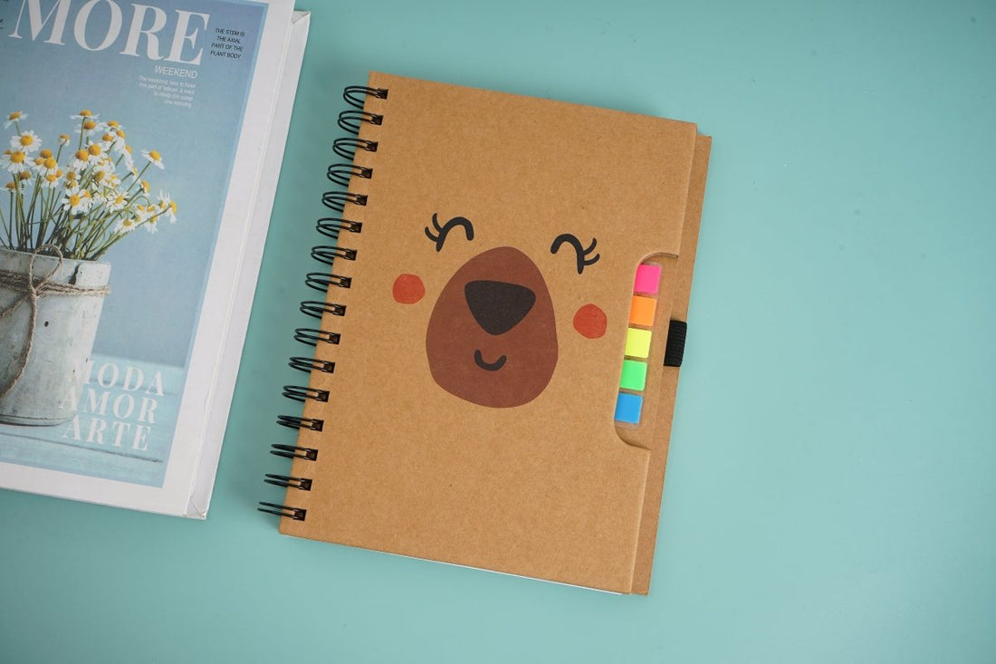 Spiral notebook with kraft brown cover, little bear face, and colorful sticky notes