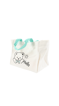 Off-white tote bag with bear 'Hello' illustration, teal shoulder handles