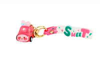 Pink keychain with gold ring, “Sweet” strap, and pink toy car charm
