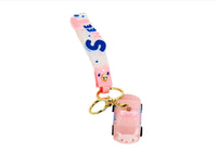 Pink keychain with gold ring, vertical “Sweet” strap, and small toy car charm