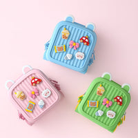 Kids cartoon backpack set in blue, pink, and green with side zippers and patch charms