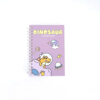 Dinosaur A6 coil notebook, purple cover with cartoon dinosaur waving and space-themed icons.