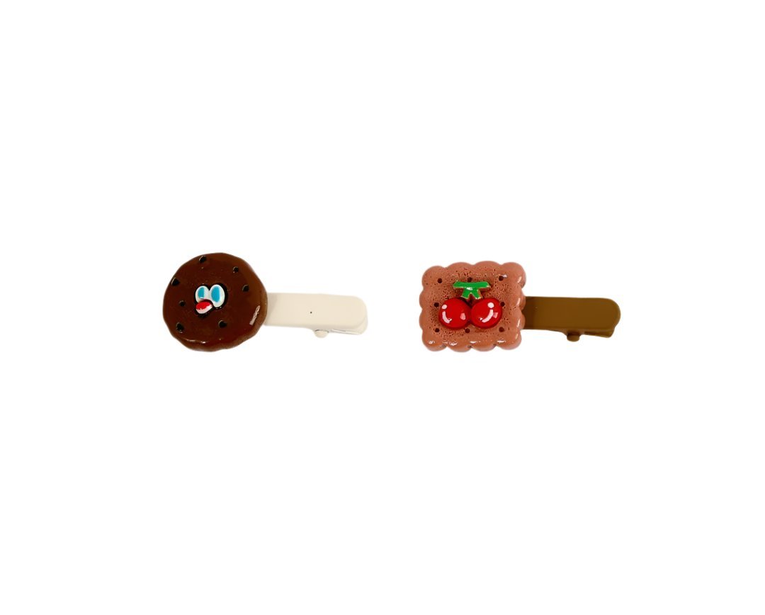 Pair of cartoon hair clips: brown cookie with glasses on cream, bear with cherries