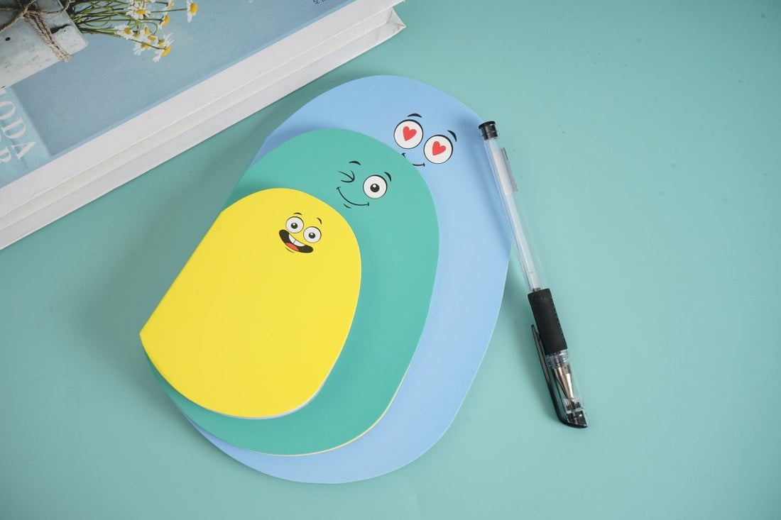 Worm-shaped notebooks in light blue and yellow with cute faces; pen included