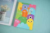 A5 hardback notebook with colorful cartoon monster cover, front visible.