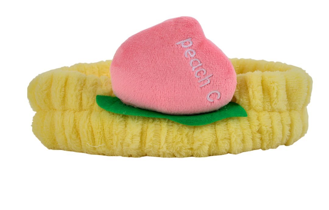 Fuzzy peach-themed headband with yellow band, pink peach slice, and green leaf detail