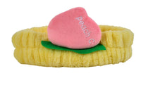 Fuzzy peach-themed headband with yellow band, pink peach slice, and green leaf detail