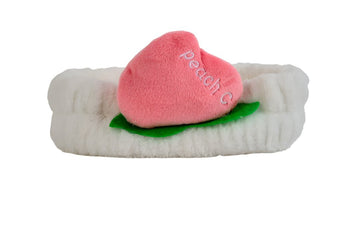 Fuzzy peach-themed headband with white band, pink peach slice, and green leaf detail