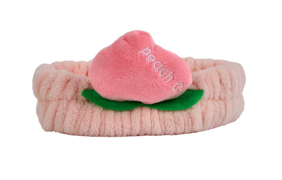 Fuzzy peach-themed headband with light pink band, pink peach slice, and green leaf detail