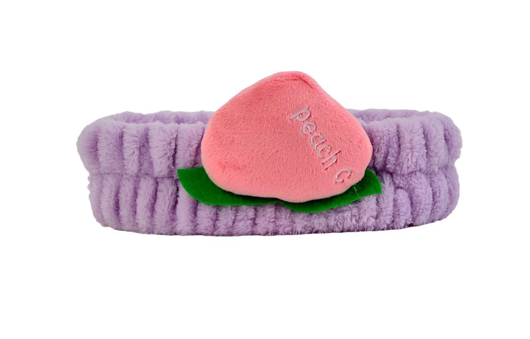 Fuzzy peach-themed headband with lavender band, pink peach slice, and green leaf detail