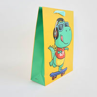 Dinosaur gift bag with cartoon dino wearing goggles, yellow front and green sides