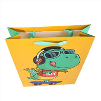 Dinosaur gift bag with cartoon dino on a skateboard, open top with handle tabs