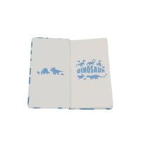 A6 hardcover notebook open, showing blank pages and dinosaur title