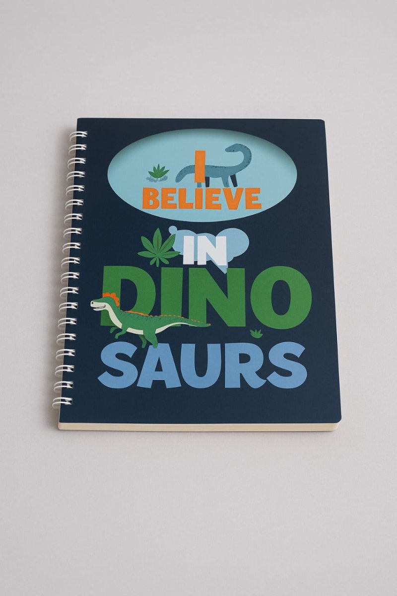 B5 spiral notebook with navy cover, dinosaur graphic, and “BELIEVE IN DINO SAURS” text