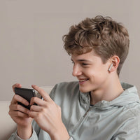 Wireless earbuds in ear on a smiling teen holding a smartphone