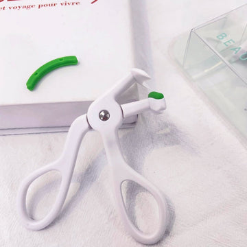 White eyelash curler with green handle, single clamp arch and round screw detail.