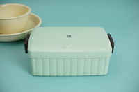 Eco-friendly lunchbox in mint with open lid and nearby food containers