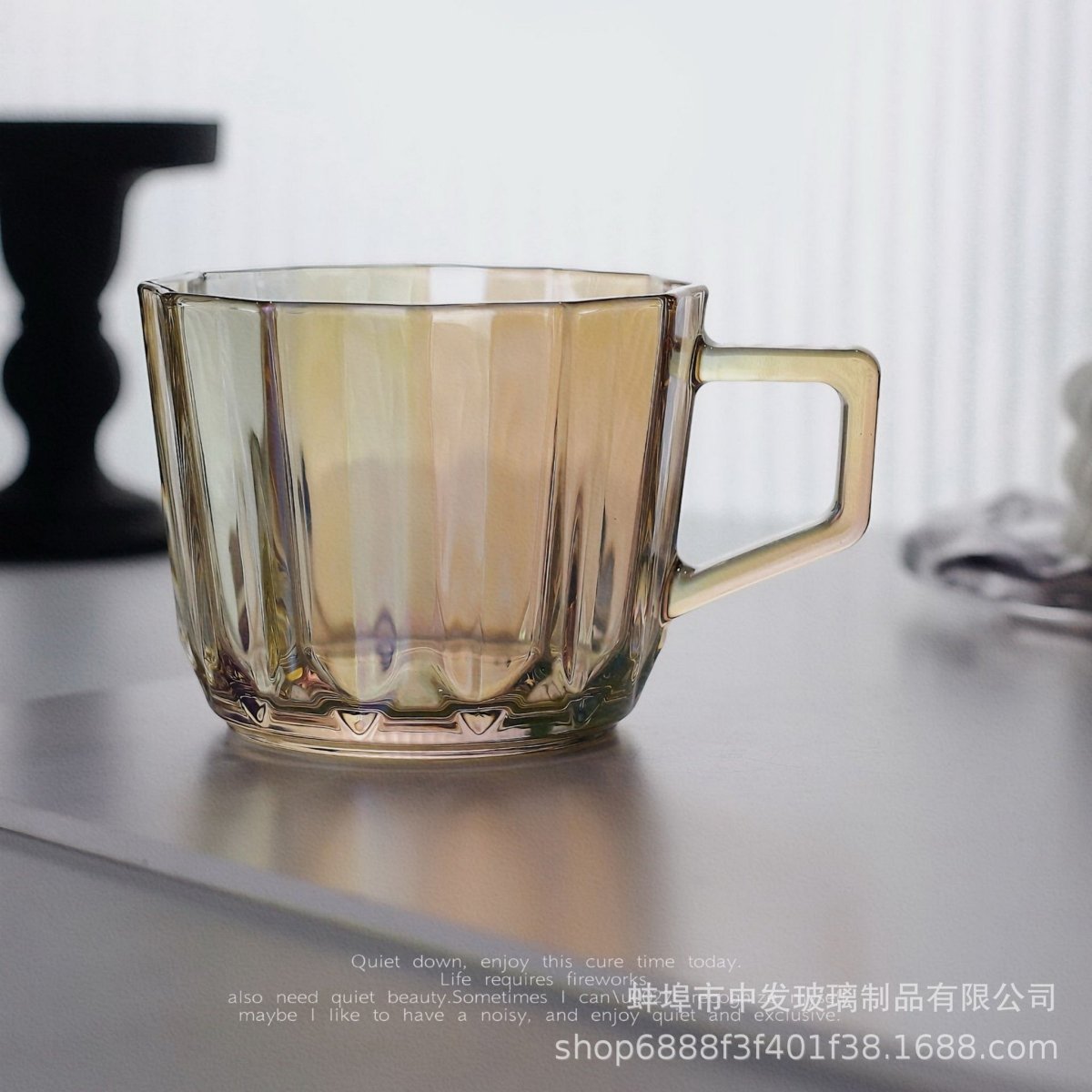 Amber glass mug with wide handle, faceted sides and clear base.