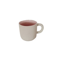 Ceramic cup with cream exterior and dark pink interior, rounded handle