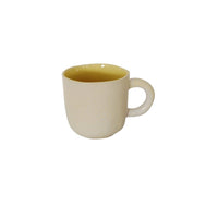 Ceramic cup with cream exterior and yellow interior, rounded handle