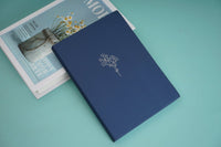 Hardback daily planner notebook, dark blue cover with embossed floral branch design