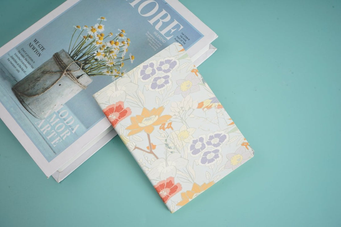 A6 notebook, white floral cover with pink and purple flowers, partially open