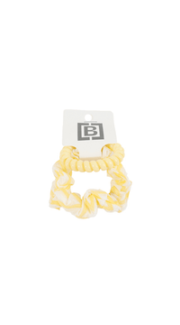 Yellow scrunchie-style hair tie with ruffled texture and tag