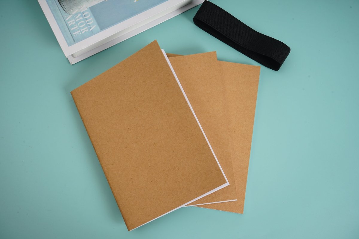 Kraft notebook with brown covers and visible white interior pages