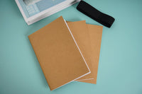 Kraft notebook with brown covers and visible white interior pages