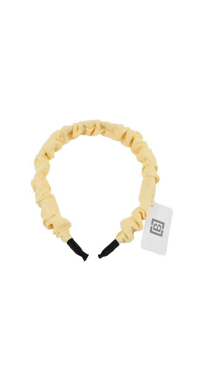 Cream ruffled headband with black ends and hang tag