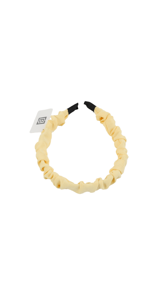 Cream loop headband with black tips and small tag