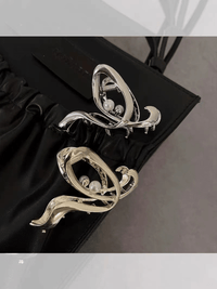 Silver hair clip with pearl accents and curved openwork swirl detail