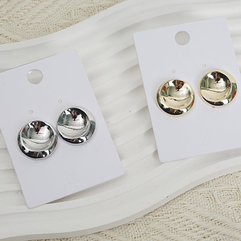 Round metal stud earrings on display card, one silver-tone pair and one gold-tone pair