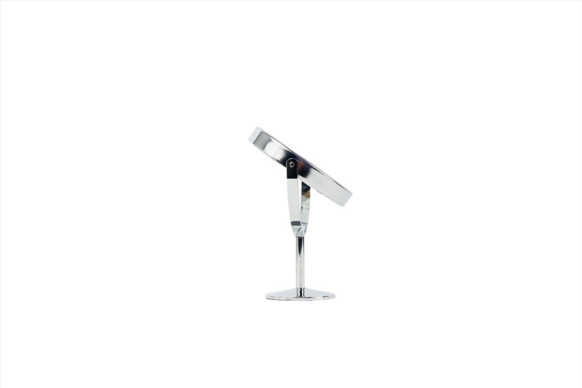 Round makeup mirror with tilting head, chrome stand, and round base, angled view.