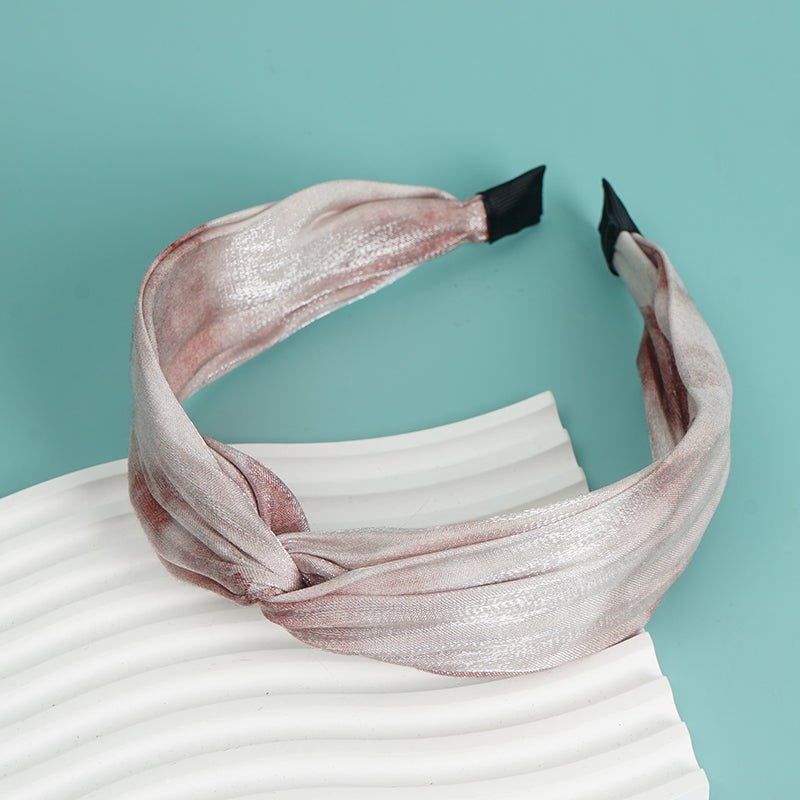 Shiny twisted headband with metallic light pink sheen and wide knotted front